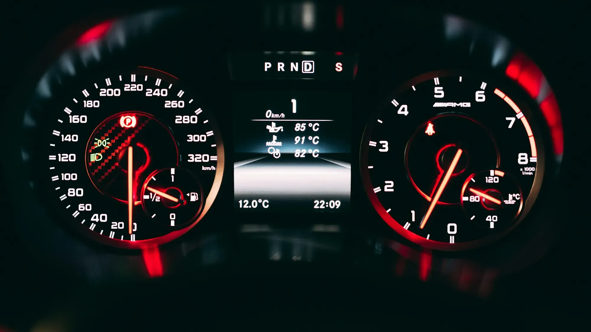 Velocímetro analógico iluminado en el tablero de un carro