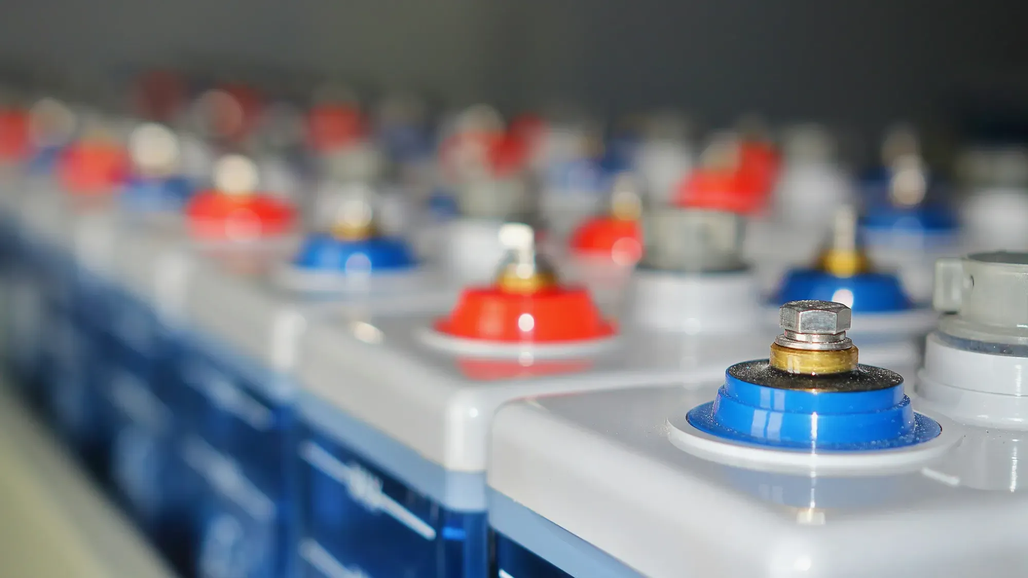Filas de celdas de batería con terminales rojos y azules
