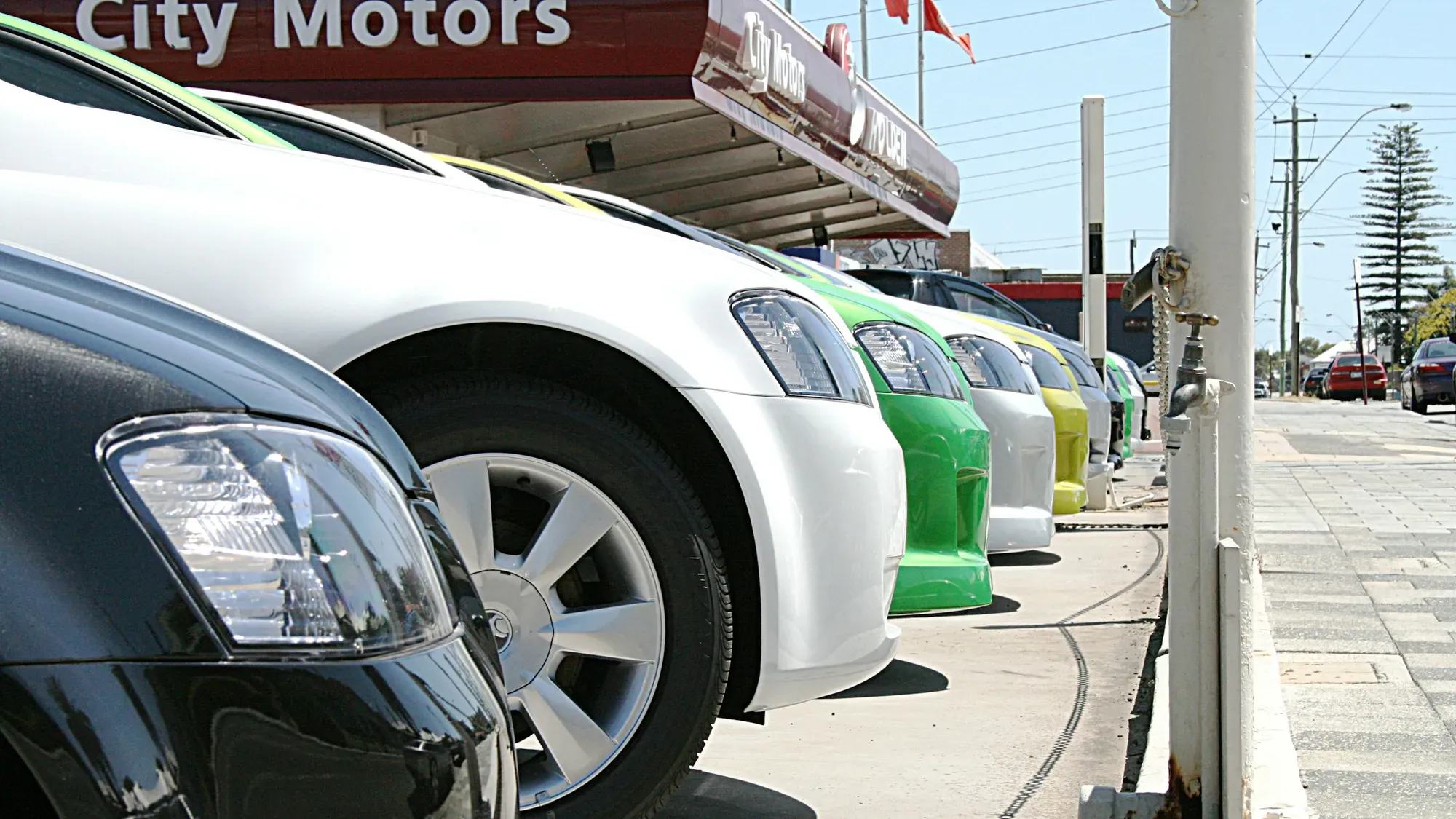 Fila de carros de varios colores parqueados en un concesionario de usados