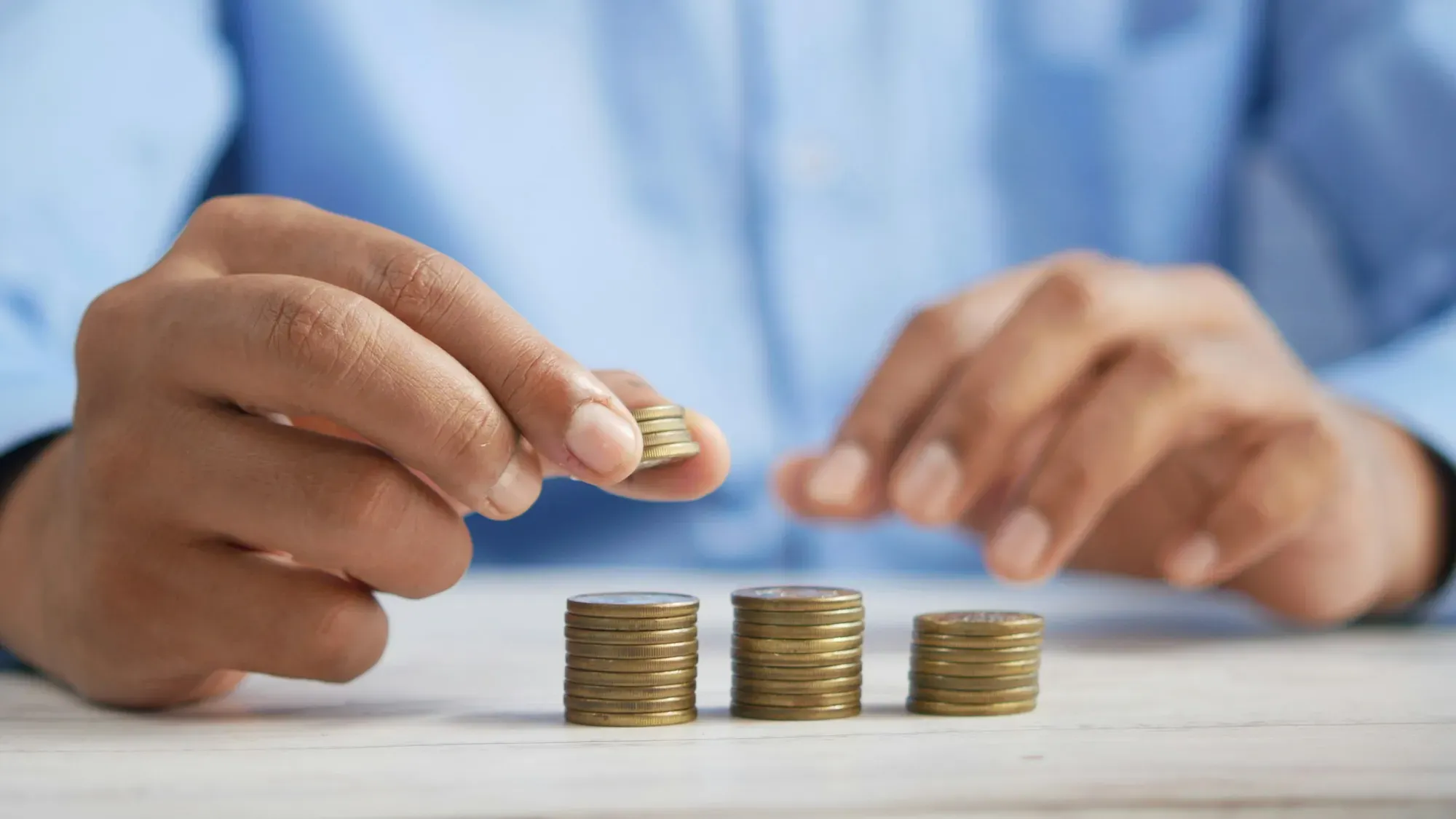 Persona apilando monedas sobre una mesa