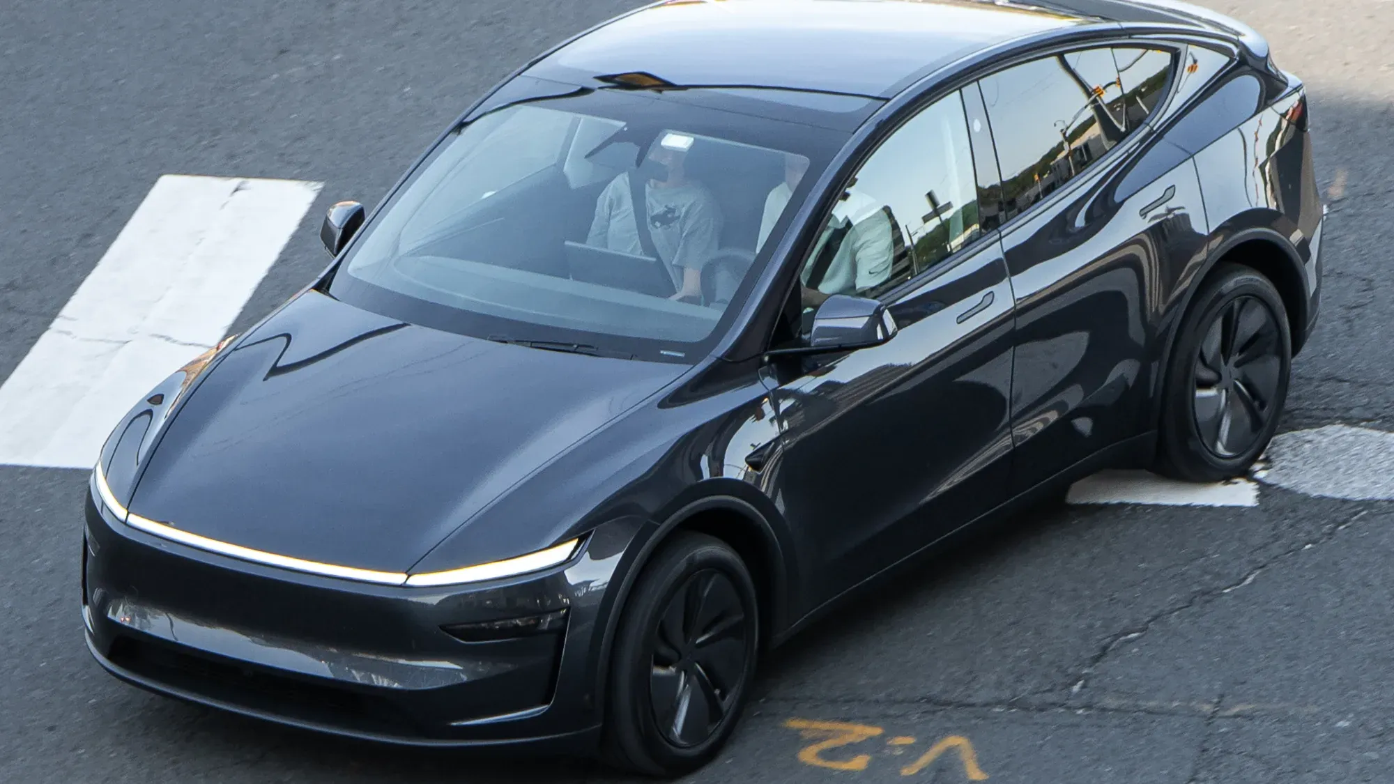 Tesla Model Y negro visto de frente y de lado en un parqueadero